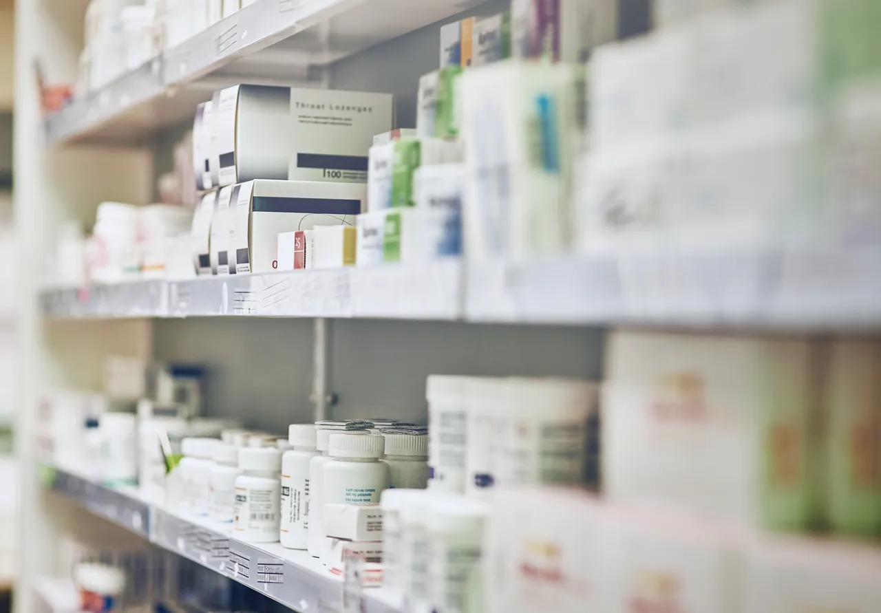 Regale in einer Apotheke mit verschiedenen Medikamentenpackungen und Flaschen.