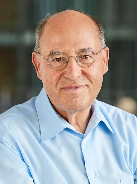 Gregor Gysi, Porträt. Der Politiker mit Glatze und runder Brille blickt freundlich in die Kamera.