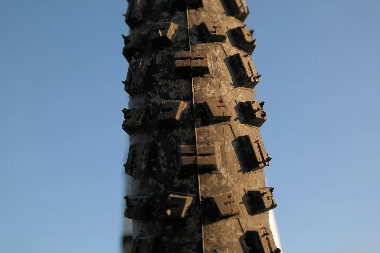 Profil eines Mountainbike-Reifens vor blauem Himmel.