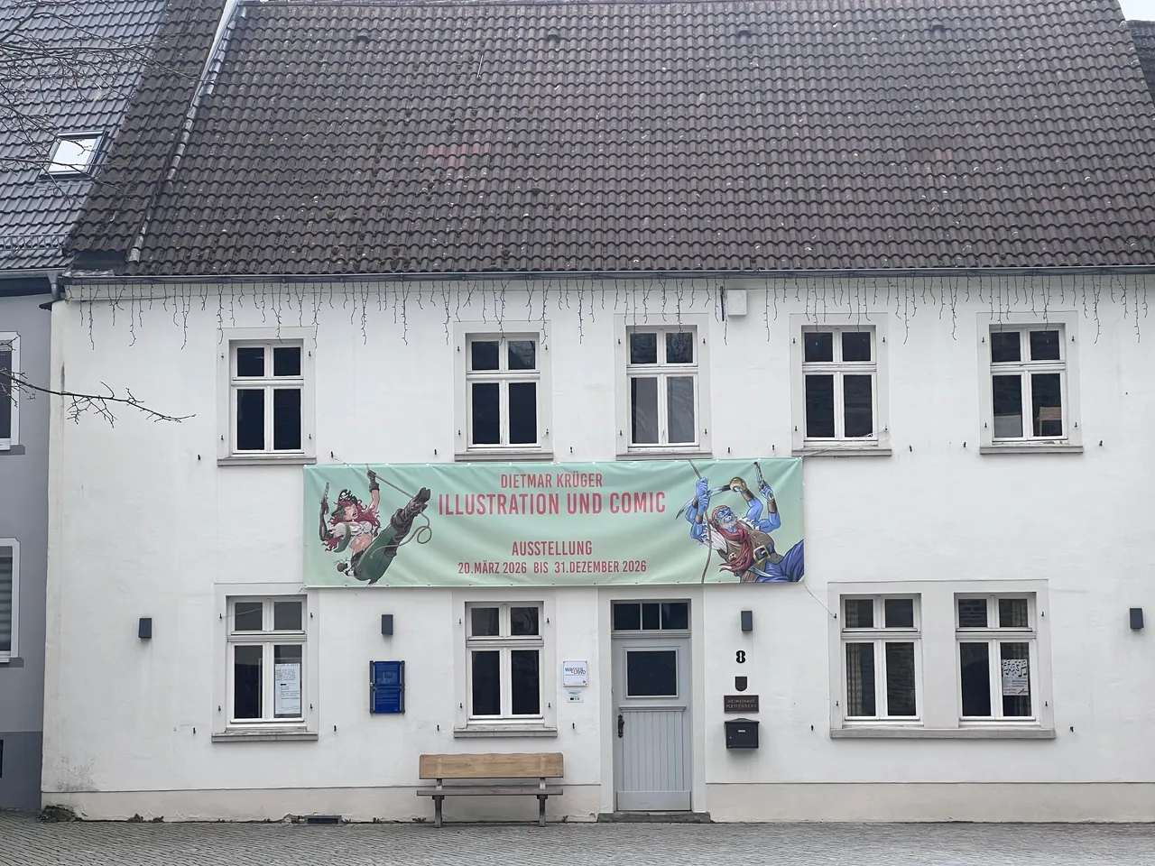 Das Heimathaus Plettenberg mit einem Banner für die Ausstellung „Illustration und Comic“ von Dietmar Krüger vom 20. März bis 31. Dezember 2026.