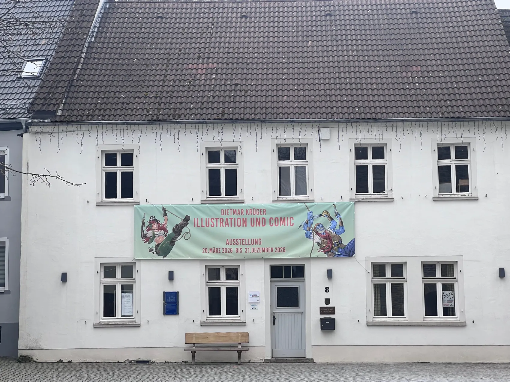 Das Heimathaus Plettenberg mit einem Banner für die Ausstellung „Illustration und Comic“ von Dietmar Krüger vom 20. März bis 31. Dezember 2026.