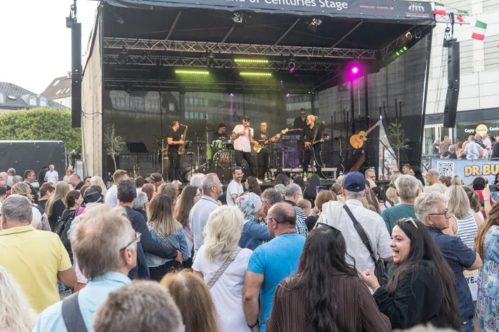 Eine Band spielt auf einer Bühne vor einer großen Menschenmenge bei der italienischen Nacht in Lüdenscheid.