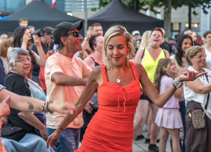 Eine blonde Frau in einem orangefarbenen Kleid tanzt bei der italienischen Nacht in Lüdenscheid.