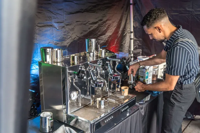 Ein Mann bereitet an einer Espressomaschine Kaffee bei der italienischen Nacht in Lüdenscheid zu.