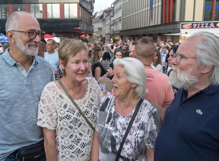 Eine Gruppe von Menschen unterhält sich lächelnd bei der italienischen Nacht in Lüdenscheid.