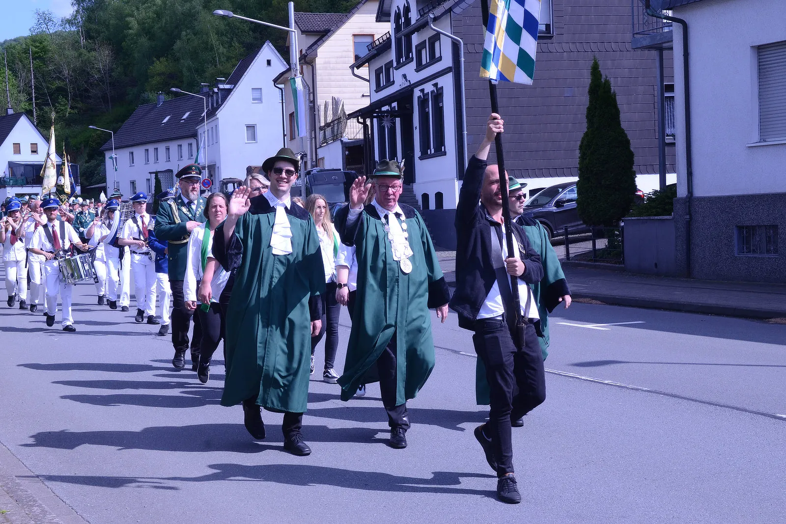 Festumzug mit Musikkapelle und festlich gekleideten Personen, darunter Mitglieder des Schützenvereins Grünetal in Plettenberg.