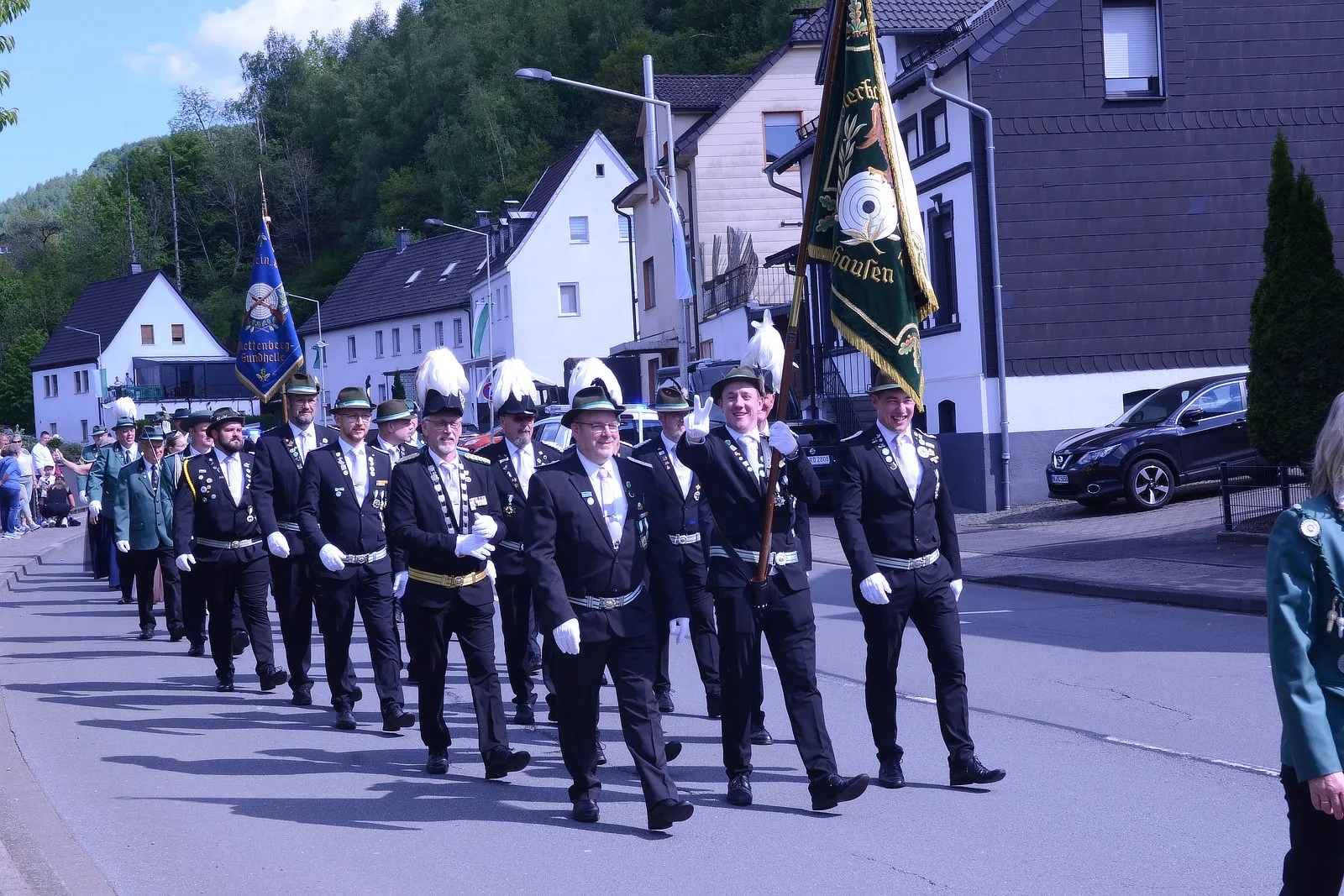Festzug des Schützenvereins Grünetal in Plettenberg mit mehreren Männern in Uniformen und historischen Fahnen.