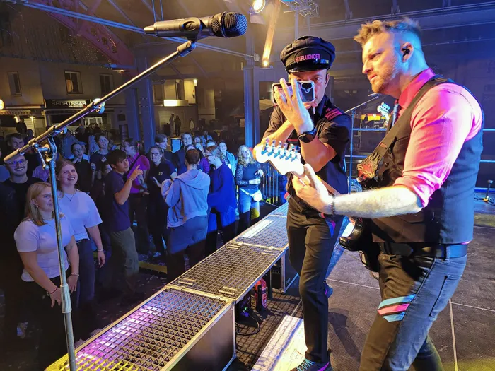 Zwei Musiker der Band Hitfluencer spielen auf einer Bühne vor einem Publikum beim Plettenberger Stadtfest.