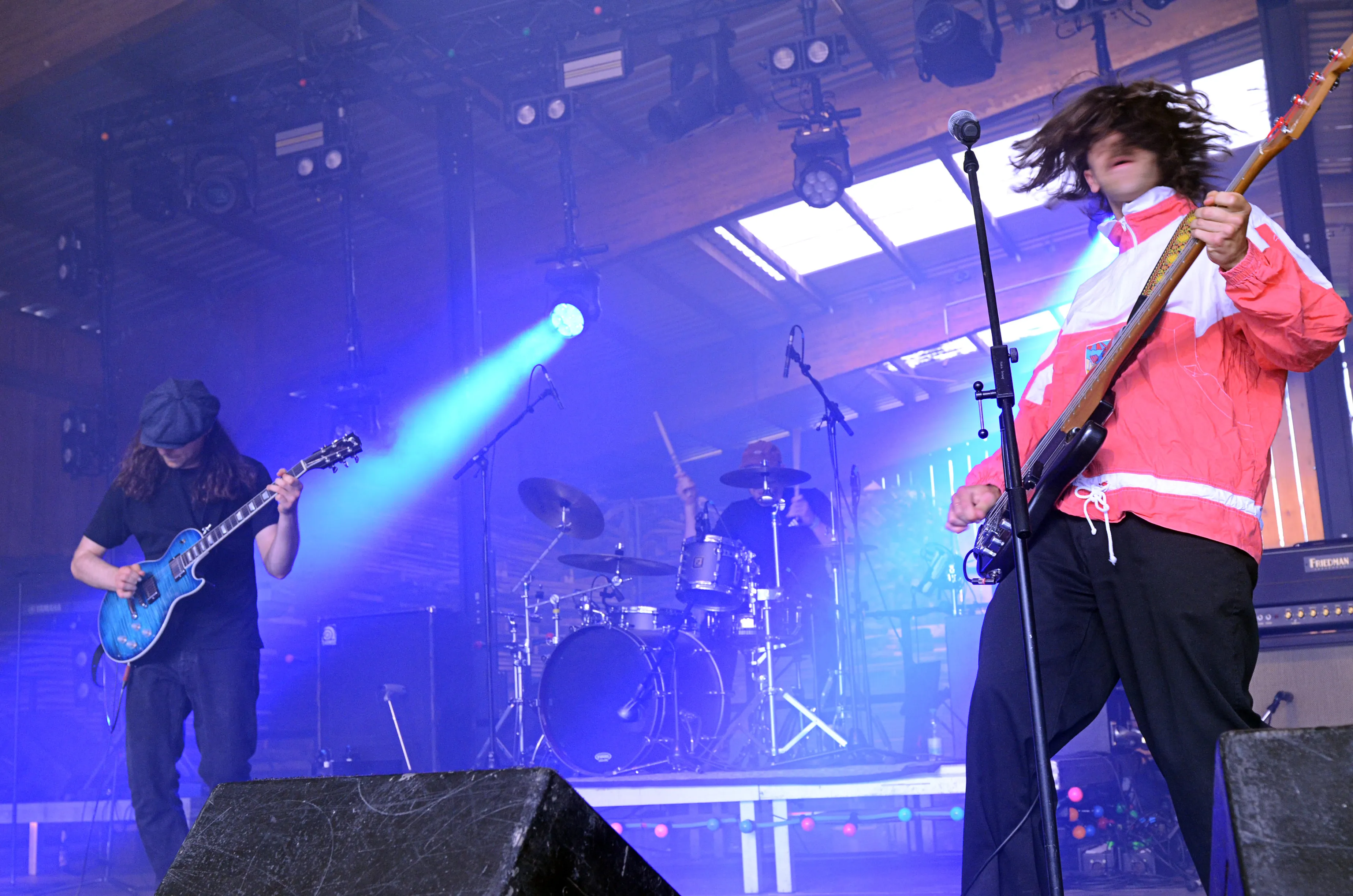 Zwei Musiker auf der Bühne des Immecke Rock Festivals: Ein Gitarrist mit Mütze und ein Sänger mit lockigem Haar und Jacke.