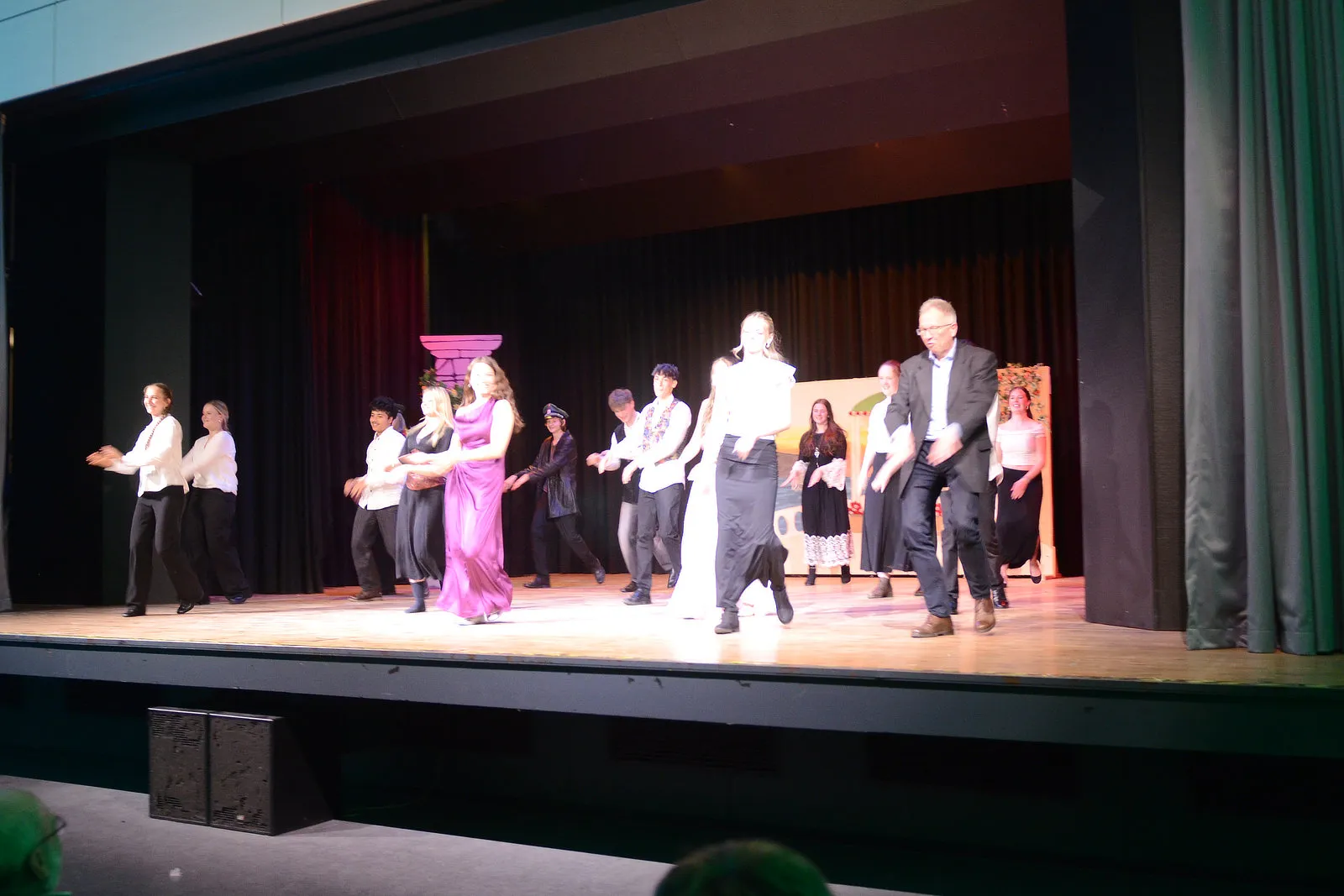 Ensemble aus Schülerinnen und Schülern in Kostümen auf einer Bühne während einer Aufführung von Shakespeares „Viel Lärm um nichts“.