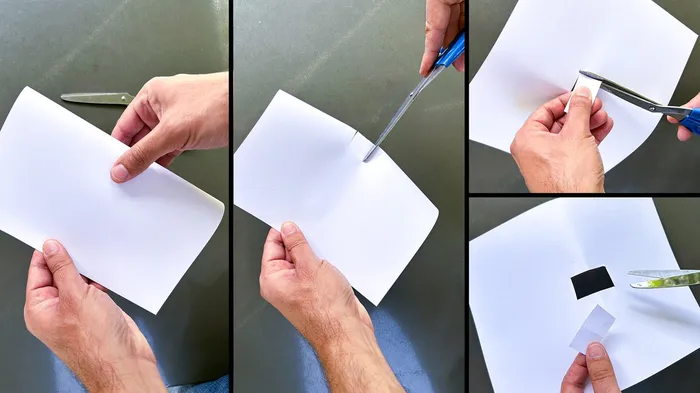 Hände schneiden mit einer Schere weiße Kartonstücke für einen Pinhole-Projektor aus.