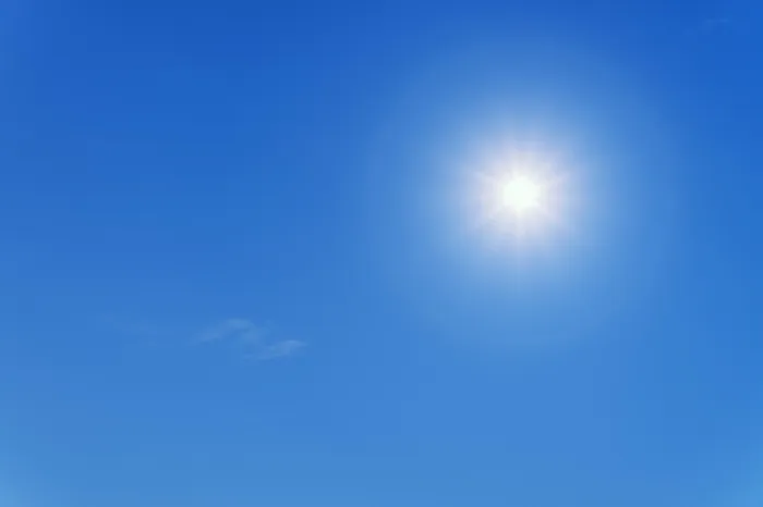 Die helle Sonne strahlt an einem klaren, blauen Himmel.